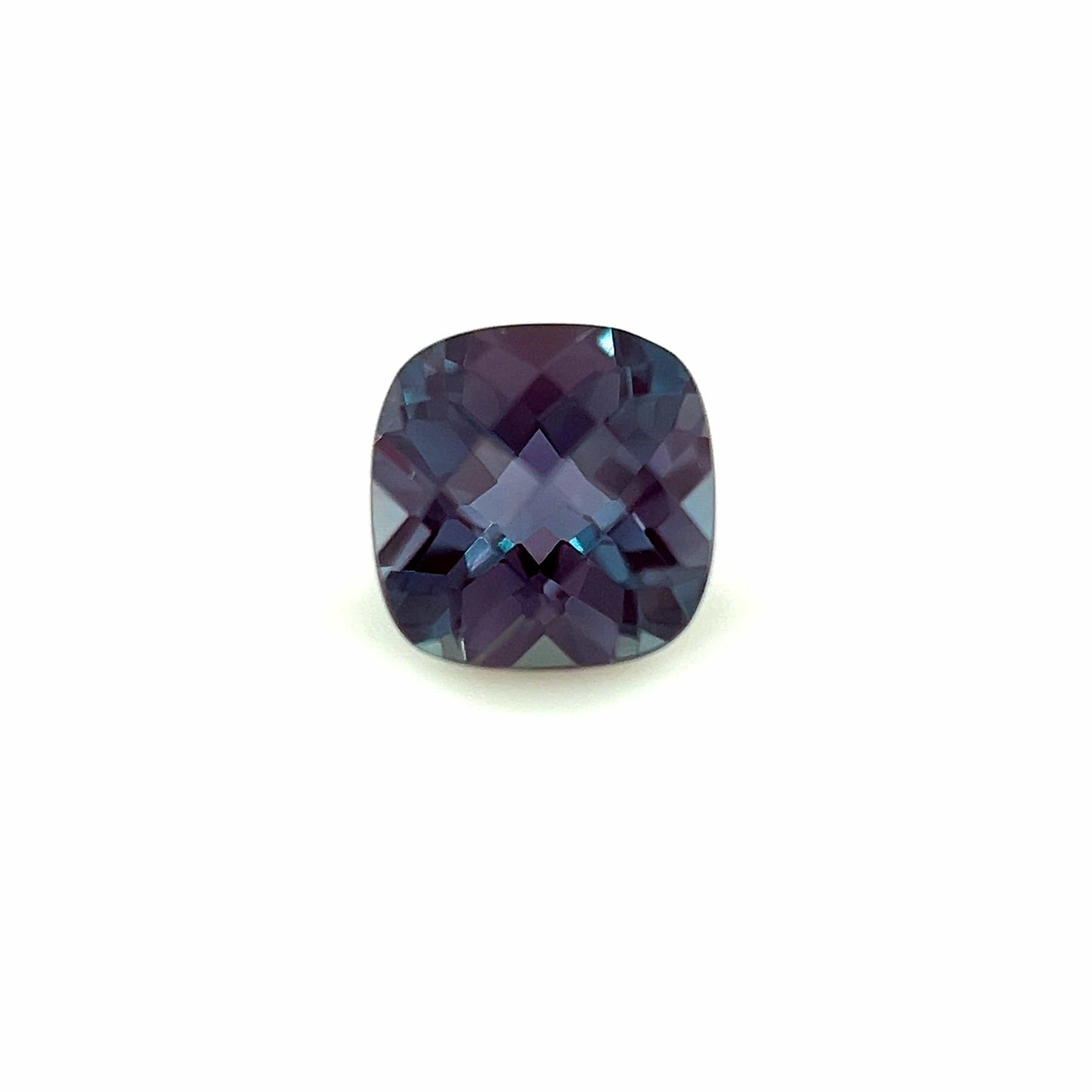 The 5mm Exceptional Cushion Checker Lab Created Alexandrite features blue, purple, and gray hues and is displayed against a plain white background.