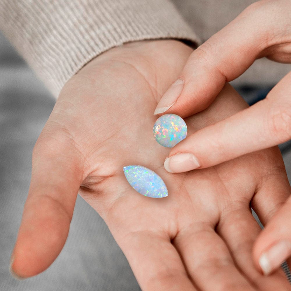 Close-up of hands with opal stones on a blurred background