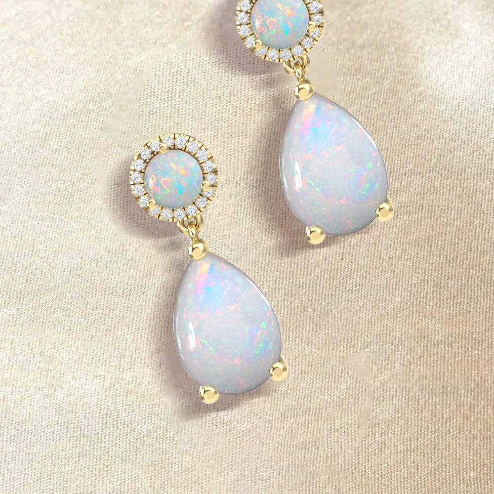 Opal earrings with gold accents on a beige fabric background