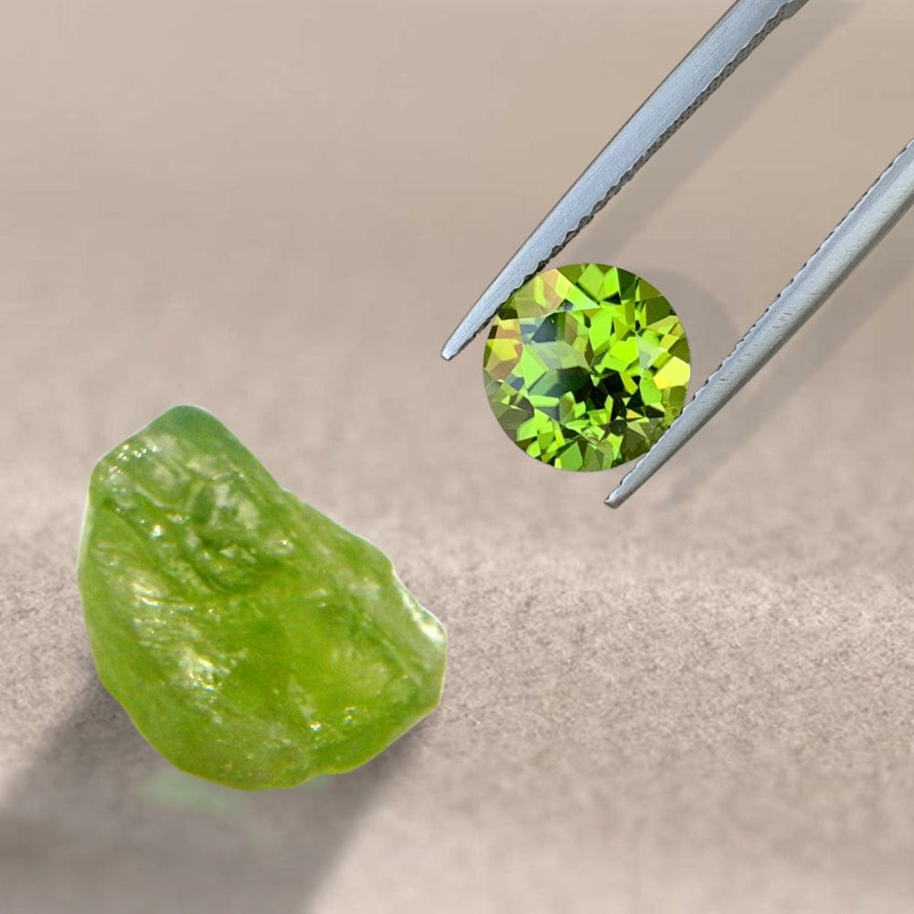 Green peridot gemstone and tweezers on a beige background