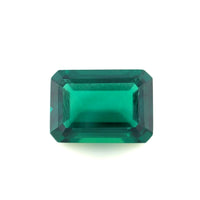 A 14.0x10.0 lab created emerald with an exceptional emerald color and beveled edges, showcasing clear facets and brilliant clarity against a white background.