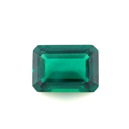 A 14.0x10.0 lab created emerald with an exceptional emerald color and beveled edges, showcasing clear facets and brilliant clarity against a white background.