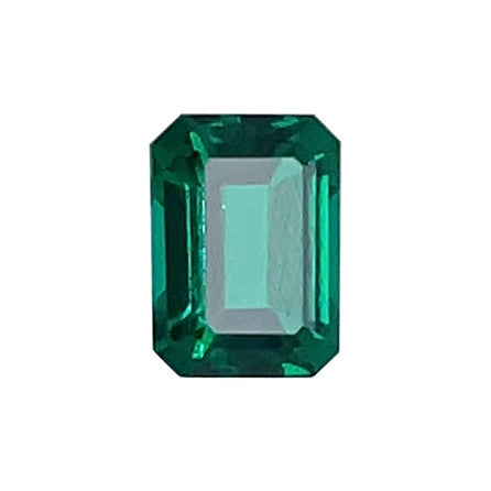 A 7x5 Exceptional Emerald Color Lab Created Emerald, emerald-cut with beveled corners and vibrant color, displayed against a white background.
