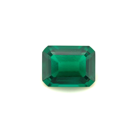 The 9x7 Exceptional Emerald Color Lab Created Emerald is a rectangular, emerald-cut green gemstone with beveled edges, shown against a plain white background.
