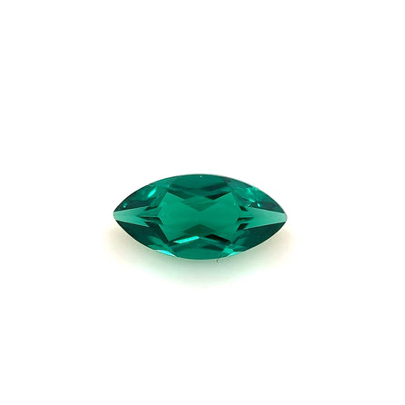 The 8.0x4.0 Exceptional Marquise Color Lab Created Emerald, with faceted surfaces, is displayed on a plain white background, highlighting the vibrant green beauty of this gemstone.