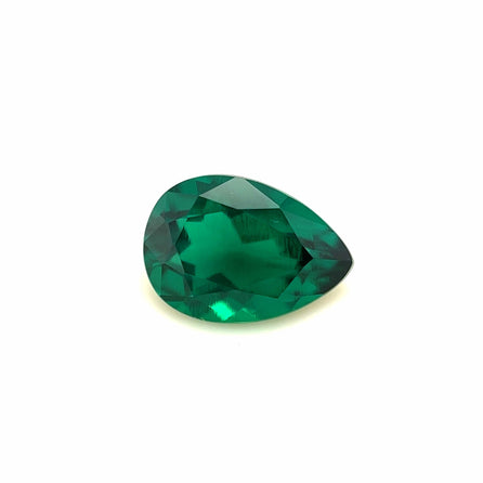 The 10x7 Exceptional Pear Zambian Color Lab Created Emerald, with its vibrant green hue and reflective faceted surface, is displayed on a plain white background.