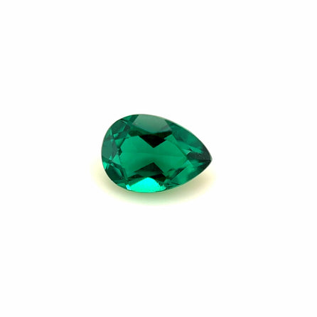 A 7x5 Exceptional Pear Zambian Color Lab Created Emerald sparkles with vivid green hues and sharp facets, beautifully showcased against a plain white background.