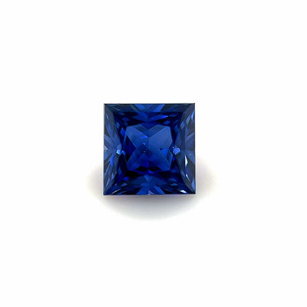 A 6mm Exceptional Square Princess Lab Created Sapphire with a deep blue hue, showcased against a plain white background.