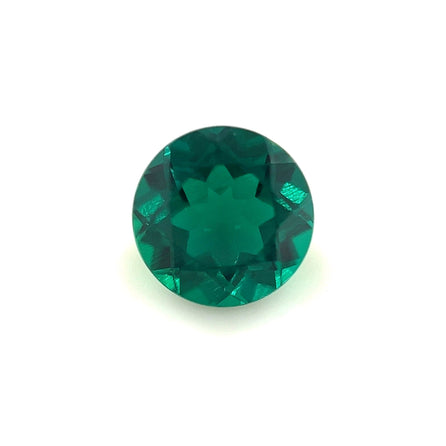 A 7.5mm Exceptional Round Zambian Color Lab Created Emerald, expertly faceted with a symmetrical star-shaped pattern at its center, is shown against a plain white background.