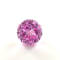 A 6mm Exceptional Round Lab Created Medium Pink Sapphire with a faceted, sparkling surface is shown against a plain white background.