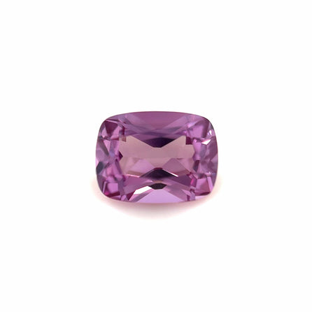 An 8x6 Exceptional Cushion Lab Created Purple Sapphire with a faceted surface is displayed against a plain white background.