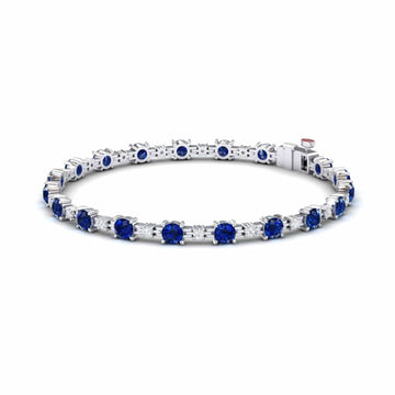 The Lab Grown Blue Sapphire & Diamond Halo Tennis Bracelet - Isabella features round blue sapphires and diamonds set in silver, with gemstones evenly spaced around the band, shown on a white background.