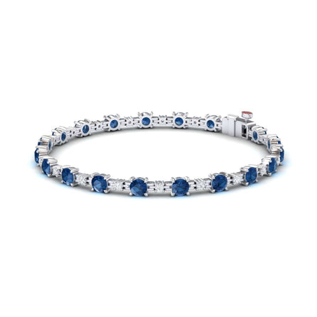 The London Blue Topaz & Diamond Tennis Bracelet - Natalia features round blue gemstones in prong settings, shown on a white background.