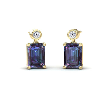 The Lab Grown Alexandrite & White Diamond Drop Earrings - Gracia feature round white diamonds above large emerald-cut alexandrite gemstones, all prong-set and shown on a white background.
