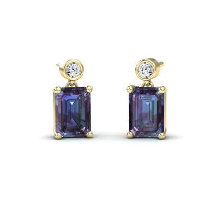 The Lab Grown Alexandrite & White Diamond Drop Earrings - Gracia feature round white diamonds above large emerald-cut alexandrite gemstones, all prong-set and shown on a white background.