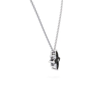The Keira Black & White Diamond Flower Necklace features a silver chain and a pendant with black and clear geometric shapes, set vertically, shown on a plain white background.