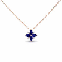 The Blue Sapphire & Diamond Flower Necklace - Keira is a gold chain necklace with a flower pendant featuring four marquise blue sapphires and four small round diamonds arranged alternately.