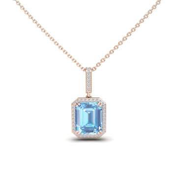 The Sky Blue Topaz & Diamond Halo Necklace - Sanya features a rose gold chain with a rectangular, emerald-cut sky blue topaz pendant surrounded by small clear diamonds.