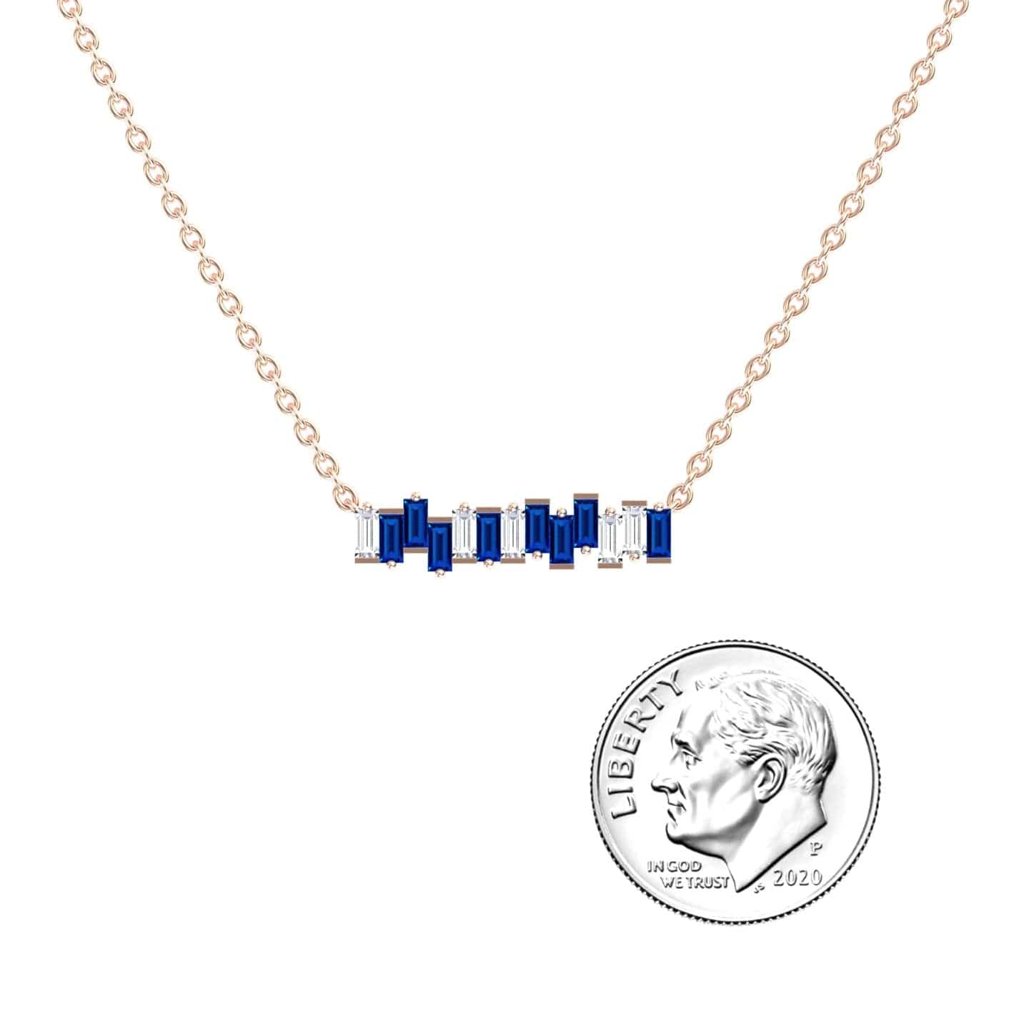 The Lab Grown Blue Sapphire & Diamond Geometric Bar Necklace - Fernanda features a gold chain with a horizontal bar pendant set with blue sapphires and diamonds, shown next to a U.S. dime for size reference.
