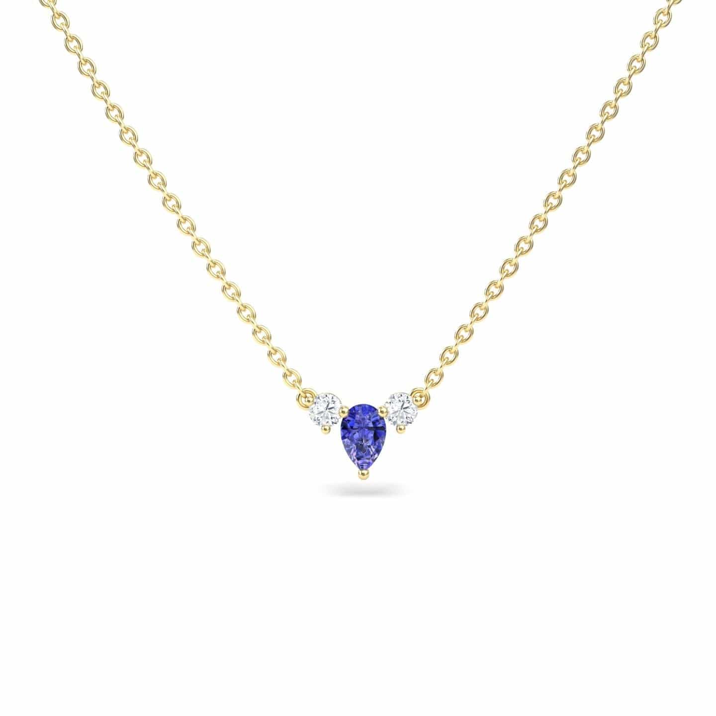 The Tanzanite & Diamond Three-Stone Necklace - Jina showcases a teardrop-shaped blue tanzanite pendant flanked by two round diamonds, all set on a gold chain and displayed against a white background.