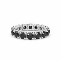 The Black Diamond Prong Set Eternity Band - Mehak features a continuous row of round black diamonds in a silver band, showcased against a white background.