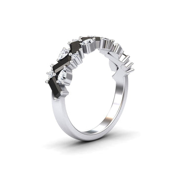 The Aimee Black & White Diamond Zigzag Eternity Band features alternating black and clear gemstones in a sleek zigzag pattern on a silver band, creating a modern, elegant look against a plain white background.
