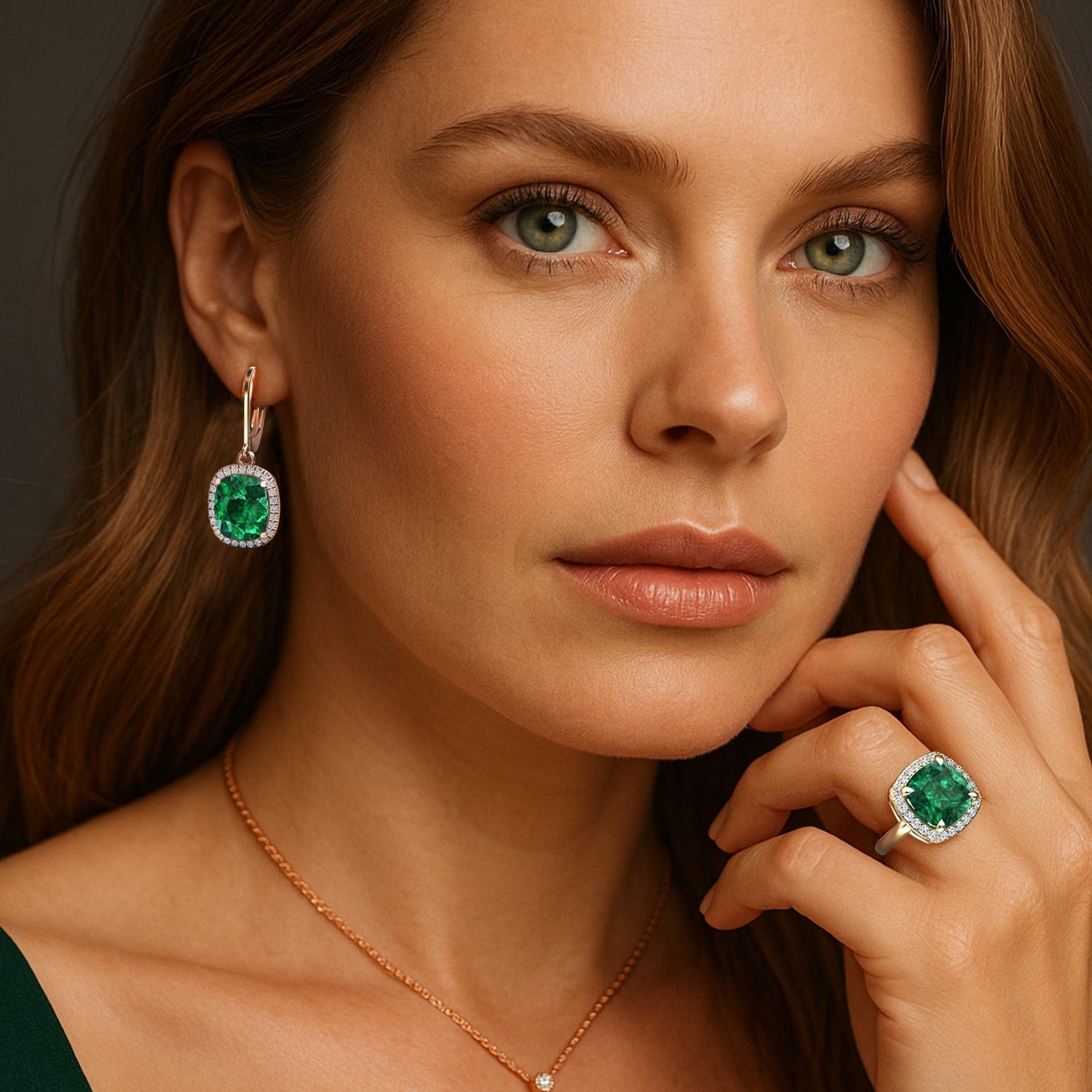 Woman wearing emerald green jewelry including earrings and a ring.