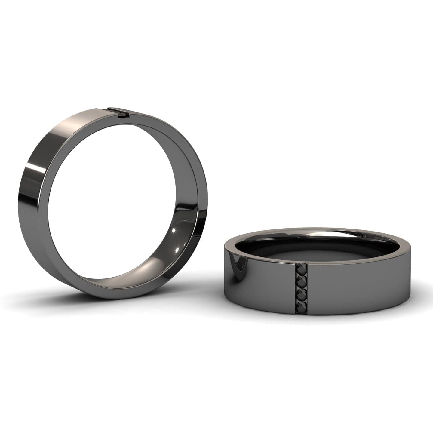 The Mens 5.5mm Black Diamond Wedding Ring - Chase is shown on a white background; one ring lies flat, displaying five black diamonds in a vertical row, while the other stands upright to reveal its smooth, metallic finish.