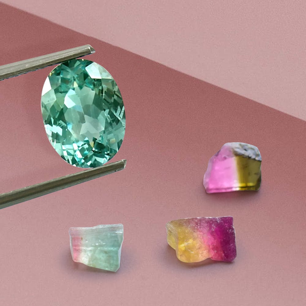Faceted green tourmaline gemstone held by tweezers on a pink background with uncut multicolored gemstones.