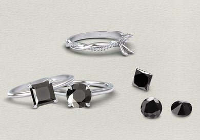 Silver rings with black diamond on a light gray background