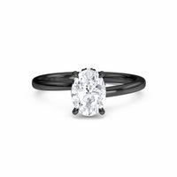 The White Diamond Hidden Halo Solitaire Engagement Ring - Lyric features a 0.20 ct oval E/VS1 diamond in a four-prong 18K blackened gold setting, shown on a white background.