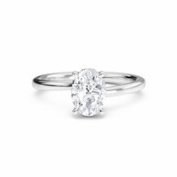 The Lyric White Diamond Hidden Halo Solitaire Engagement Ring in 18K white gold features a 0.200 carat oval diamond, E color, VS1 clarity, set in a four-prong setting and displayed on a white background.